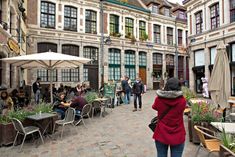 people are sitting at tables in an open courtyard