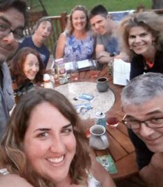 a group of people sitting around a wooden table