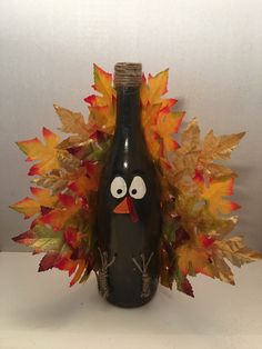 a wine bottle decorated with leaves and a turkey