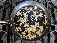 a frying pan filled with lots of food on top of a gas stovetop