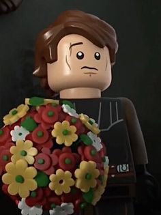 a lego star wars character holding a bouquet of flowers in front of a clock face