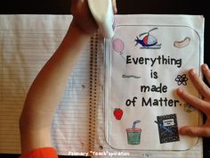 a child's hand holding up a book with writing on it that says everything is made of matter