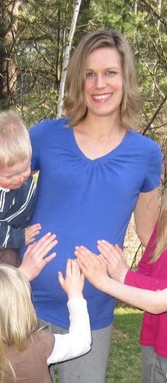 a group of people standing around each other with their hands in front of the woman