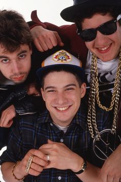 three young men wearing hats and sunglasses posing for the camera with their arms around each other