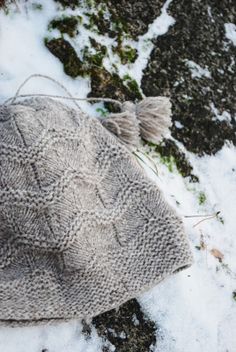 a knitted hat sitting on top of snow covered ground