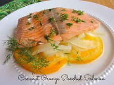 a white plate topped with salmon and orange slices