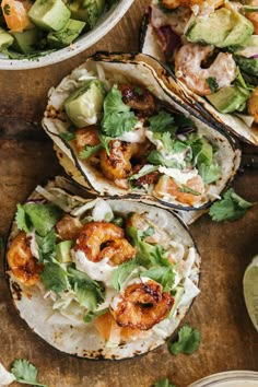 shrimp tacos with avocado, cilantro and lime dressing on a wooden table