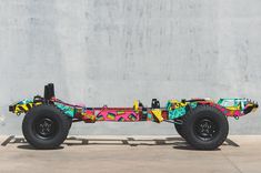 an off - road vehicle is painted with bright colors and designs on it's wheels