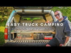 a man is sitting in the back of a truck with his camping gear on it