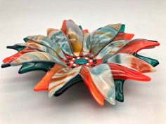 a colorful glass flower sitting on top of a white table