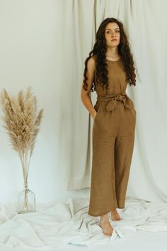 DETAILS: - 100% linen jumpsuit - sleeveless - elastic waist - pockets - wide leg - wrap back LENGTH inseam is 23" / 51cm from the crotch point.  MODEL is pictured above in mid-weight Ginger color. Also available with a short sleeve - https://www.etsy.com/listing/599657029/linen-jumpsuit-short-sleeve-wrap-back FABRIC: - The mid weight linen is 5.3 oz / 150g. It is very soft and has a a nice linen texture with the little imperfections that make linen so lovely.  - All of our linen is OEKO-TEX Standard 100 certified.  CARE: - The fabric is prewashed to minimize shrinking.  - The garment can be machine washed in lukewarm or cool water.  - It can be hung to dry or tumbled to dry on medium heat.  - Detergent free of additives, irritants, softeners, fragrances, and dyes is recommended. - For best Sleeveless Brown Jumpsuits For Workwear, Chic Linen Jumpsuits And Rompers With Tie Waist, Wide Leg Linen Jumpsuits And Rompers For Beach, Linen Wide Leg Jumpsuits For Beach, Beach Linen Wide Leg Jumpsuits And Rompers, Sleeveless Brown Jumpsuits And Rompers With Pockets, Chic Linen Jumpsuits And Rompers With Pockets, Sleeveless Brown Jumpsuit With Pockets, Brown Sleeveless Jumpsuit With Pockets