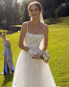 a woman in a wedding dress standing next to another woman