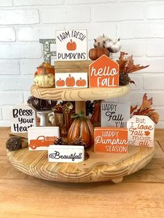 a three tiered tray filled with fall decorations