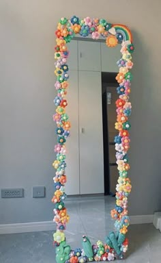 a large mirror that is made out of balloons and balls in the shape of a rainbow