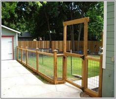 a fenced in yard with a gate and grass area next to the garage door