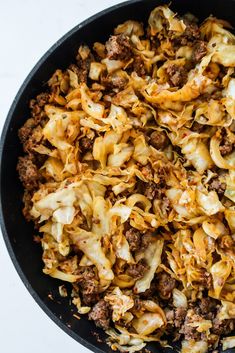 a skillet filled with pasta and meat