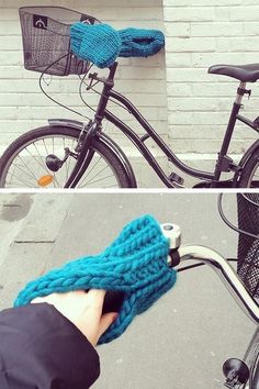 a person holding a blue knitted mitt next to a bicycle with the handlebars down