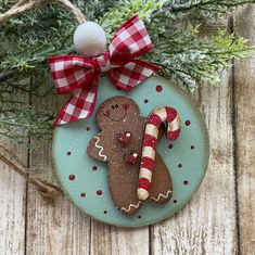 a christmas ornament with a gingerbread man and candy canes on it