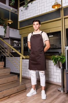 a man standing in front of a kitchen counter with his hands on his hips while wearing an apron