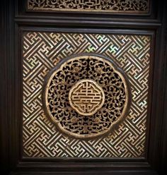 an intricate carved design on the side of a wall in a chinese style room with wood trimmings