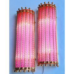 two pink and gold wall lights on a blue background