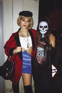 two women in costumes standing next to each other and one is wearing a skeleton mask