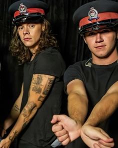 two men in police uniforms with tattoos on their arms