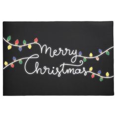 a black door mat with christmas lights on it