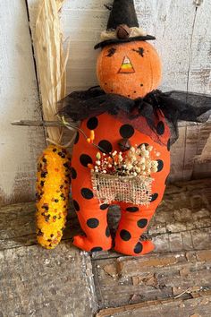 a scarecrow and corn on the cob are sitting next to each other in front of a door