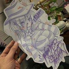 a person holding up a sticker with an anime character on it