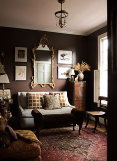 a living room filled with furniture and pictures on the wall