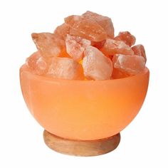 an orange bowl filled with sugar on top of a wooden table