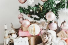 christmas ornaments hanging from the ceiling in front of a tree with presents under it by jovo studio for stocks & bond