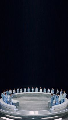 a group of people sitting on top of a round table in front of a black background