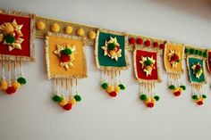 some decorations are hanging on the wall in front of a white wall with red, yellow and green colors