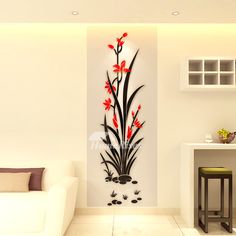 a living room with a white couch and red flowers on the wall next to it