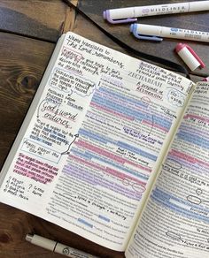 an open book with writing on it next to some markers and pencils in front of it