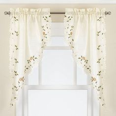 a window with white curtains and flowers on it