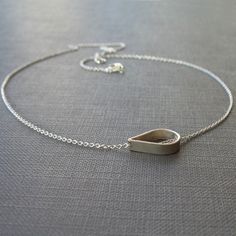 A single open teardrop in sterling silver floats freely across a small but sturdy sterling silver chain. A necklace simple enough for everyday and special enough for evening. The teardrop measures 1/2 inch across. Choose your necklace length from the drop-down menu; the necklace pictured on the model is 16 inches long. Modern Teardrop Drop Necklace As A Gift, Modern Teardrop Drop Necklace For Gift, Silver Drop Necklace With Delicate Chain And Teardrop Pendant, Silver Drop Necklace With Teardrop Pendant, Everyday Delicate Teardrop Drop Necklace, Sterling Silver Drop Necklace With Teardrop Pendant, Sterling Silver Teardrop Drop Necklace With Delicate Chain, Delicate Sterling Silver Teardrop Pendant Necklace, Modern Sterling Silver Teardrop Pendant Necklace