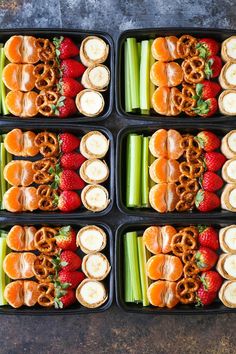 six trays filled with pretzels, strawberries and celery