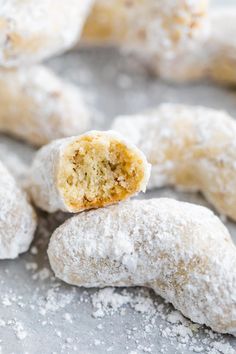 powdered sugar coated doughnuts on top of each other with a bite taken out