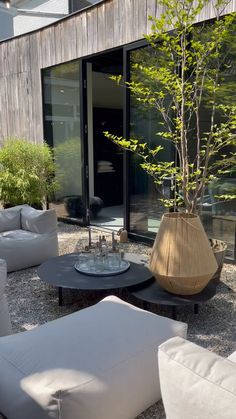 an outdoor living area with white furniture and plants