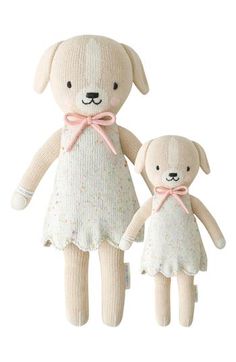 two stuffed animals are wearing dresses and standing next to each other on a white background