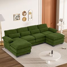 a green sectional couch sitting on top of a white rug next to a coffee table