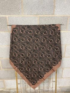 a brown and black scarf hanging on a brick wall