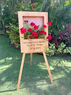 a wooden sign with red flowers in it