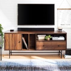 a flat screen tv sitting on top of a wooden entertainment center in a living room