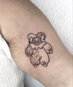 a small teddy bear tattoo on the arm