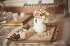 a white vase filled with flowers sitting on top of a table next to other items