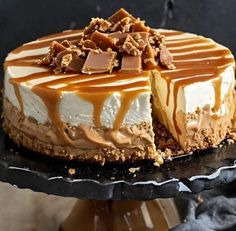 a cheesecake with caramel and chocolate toppings on a cake platter, ready to be eaten